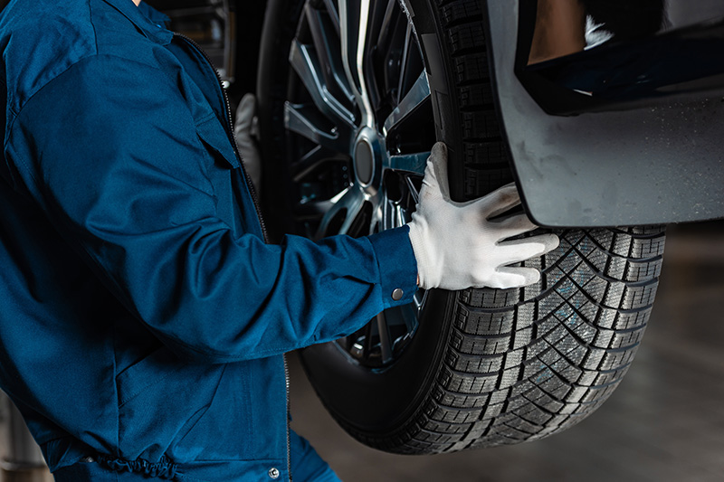 Auto technician installing tire on vehicle during tire service