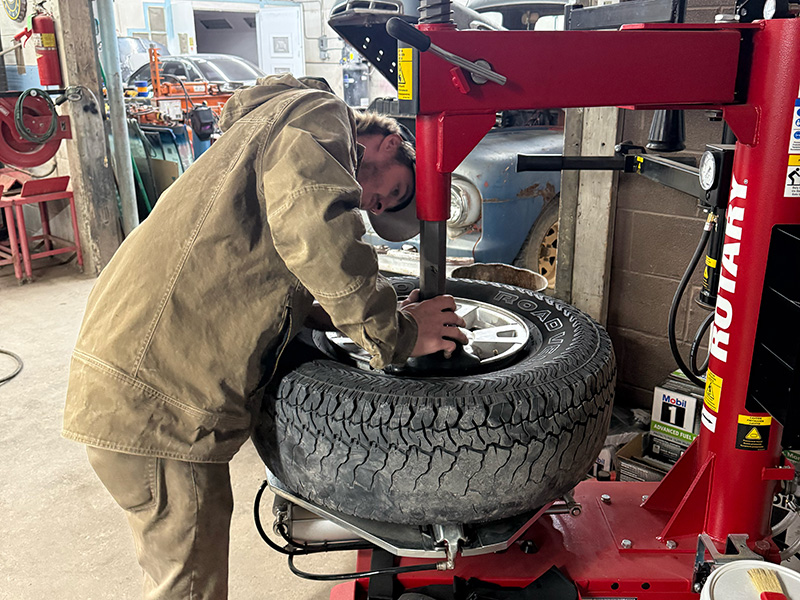 Auto technician replacing tire at auto repair shop in Hot Springs SD