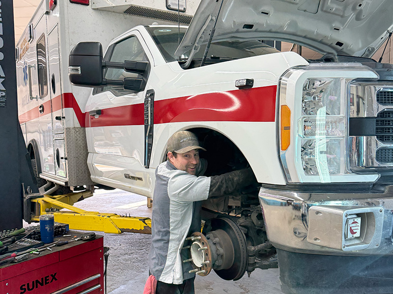 Auto technician repairing heavy-duty truck during brake and suspension service